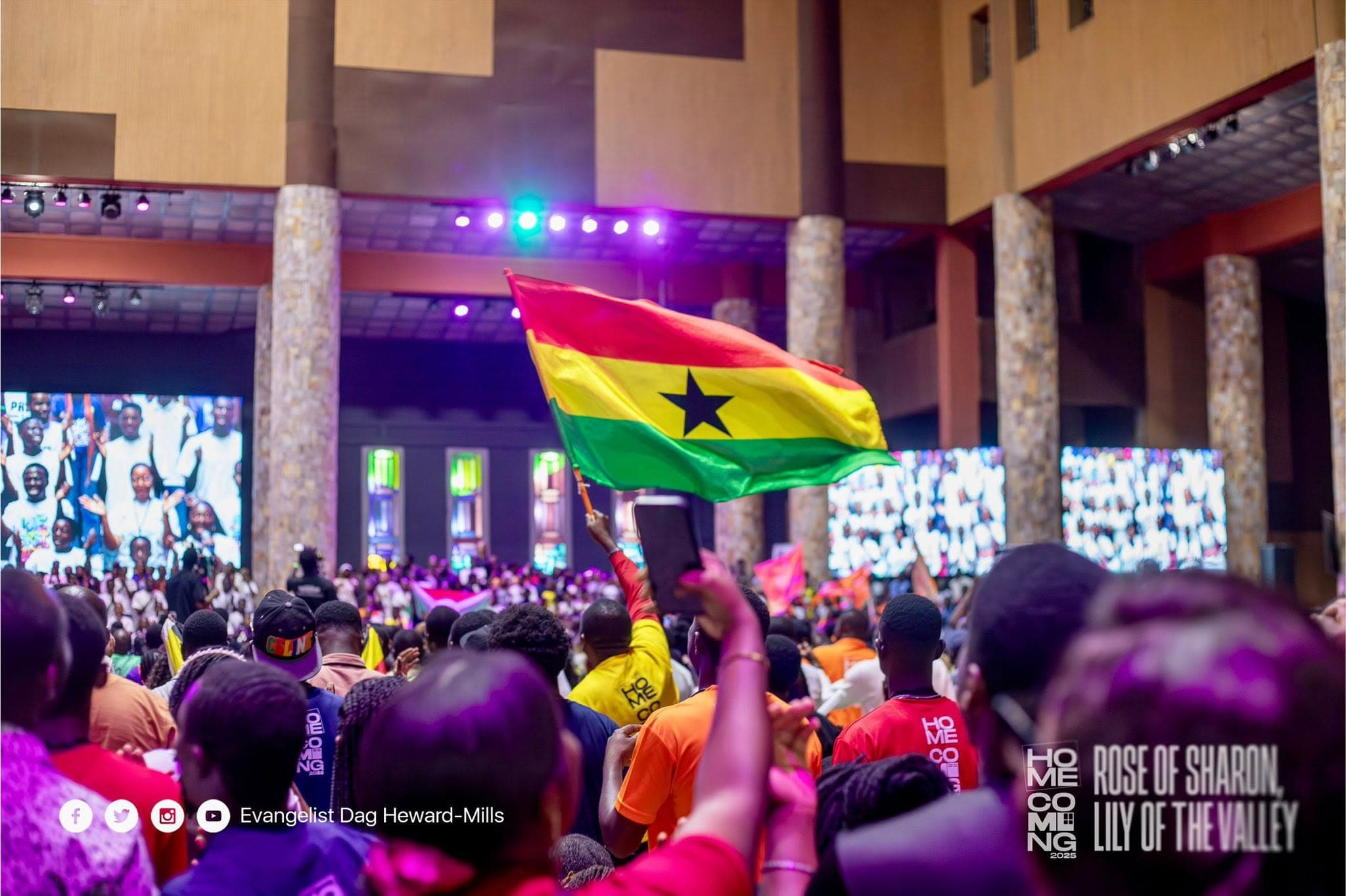 The crowd at Homecoming 2025 waving the Ghana flag in the convention hall